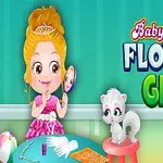 Bé gái mặc váy hồng ngồi cạnh chú mèo, cầm gương và nhìn vào gương với nền tường xanh và chữ Baby Hazel Flower Girl