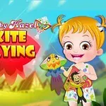 Một bé gái tóc vàng cầm diều đứng trước cảnh nền xanh với chữ Kite Flying