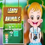 Hình ảnh bé gái cười tươi đứng cạnh bảng hiệu Learn Animals với nhiều con vật xung quanh