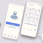 Hai điện thoại hiển thị ứng dụng trò chơi đố số trên bàn với đồng hồ trắng, sổ ghi chép, bút và cây xanh