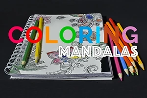 Sổ tay tô màu mandala với bút chì màu đặt bên cạnh