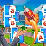 Người phụ nữ tóc vàng đứng trước một bảng với các lá bài và một tên lửa đang bay lên
