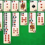 Một bàn cờ bài với các lá bài xếp chồng lên nhau trên nền xanh lá cây