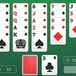 Bàn với các lá bài được sắp xếp thành bảy cột trên nền xanh lá, bao gồm các quân bài từ 2 đến K cơ, rô, bích, nhép và một bộ bài úp xuống