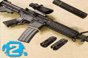 Khẩu súng trường và các bộ phận phụ kiện như ống ngắm, ống giảm thanh và các nòng thay thế được đặt trên mặt phẳng màu nâu nhạt, với ký hiệu số 2 màu xanh lam ở góc dưới bên trái