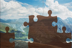 Hình ảnh ghép hình với các miếng ghép lớn che phủ một cảnh núi non xanh tươi và bầu trời trong xanh có mây