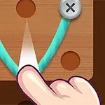 Ngón tay chạm vào sợi dây xanh buộc giữa hai chiếc đinh vít trên bề mặt gỗ
