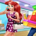 Một cô gái tóc đỏ mặc váy chấm bi tím đang cười trong cửa hàng, trong khi một chàng trai mặc áo sơ mi xanh đang cầm nhiều hộp quà đủ màu