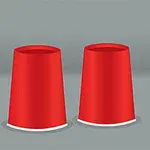 Ba chiếc cốc đỏ úp ngược trên bề mặt với quả bóng màu vàng nằm bên cạnh một trong những chiếc cốc