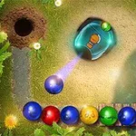Hình ảnh hiển thị những viên bi màu sắc xếp hàng lối uốn cong trên nền cỏ, với một khẩu bắn đá đang bắn bi màu tím