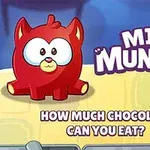 Một sinh vật đỏ giống mèo với đôi mắt to đứng bên cạnh chữ MINI MUNCHER trên nền màu vàng và xanh dương, phía dưới có các thanh sô cô la