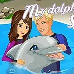 Hai người trẻ vui vẻ cùng một chú cá heo trong bể bơi với chữ My Dolphin Show 2 ở trên