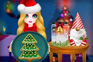 Một cô gái đội mũ ông già Noel cầm đĩa bánh quy hình cây thông Noel, bên cạnh là đồ trang trí Giáng sinh trên bàn nhỏ