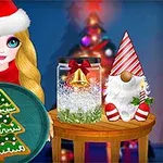Một cô gái đội mũ ông già Noel cầm đĩa bánh quy hình cây thông Noel, bên cạnh là đồ trang trí Giáng sinh trên bàn nhỏ
