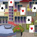 Các lá bài được sắp xếp trên nền cảnh quan thành phố với cây cầu nhỏ bắc qua kênh nước và tòa nhà có cửa sổ và ban công