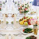 Bàn tiệc sang trọng với hoa và trái cây trang trí trên đĩa tại một sự kiện