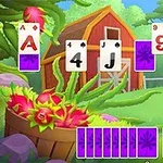 Những lá bài được sắp xếp trước cảnh vật với ngôi nhà kho đỏ, cây xanh, và một giỏ hoa đầy màu sắc