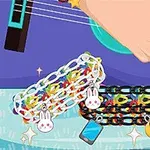 Một bàn tay chơi đàn guitar với các vòng tay trang trí có mặt hình thỏ, điện thoại di động và mặt trăng