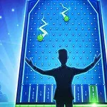 Người đang đứng trước bảng trò chơi lớn với các đèn và quả bóng xanh lá cây, phía sau là khán giả ngồi trong bóng tối