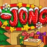 Bảng hiệu ghi X-JONG phủ tuyết, trang trí với ngôi sao, bông tuyết và hộp quà, cạnh một cây thông Noel